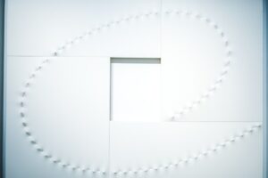 Minimalistisk vit yta med snörning som bildar en spiral, relaterat till design.